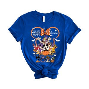 May include: A royal blue short-sleeve t-shirt featuring a graphic of Disney characters in Halloween costumes, a castle, and the text "NOT SO SCARY HALLOWEEN PARTY!", "CAMERON", and "2020" with a large orange Mickey Mouse ear outline and bats.
