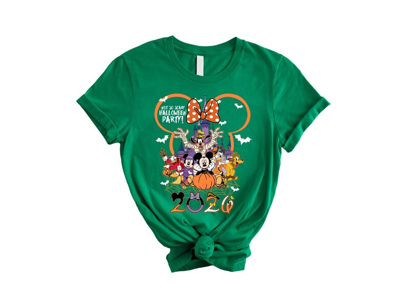 May include: A green short-sleeve t-shirt featuring a graphic of Disney characters in Halloween costumes. The design includes a pumpkin, a castle, bats, and the text "NOT SO SCARY HALLOWEEN PARTY!" with the year "2020" printed at the bottom.