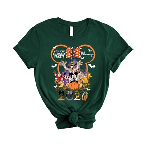 May include: A dark green short-sleeve t-shirt featuring a graphic of Disney characters in Halloween costumes, a pumpkin, and a castle. The text reads "NOT SO SCARY HALLOWEEN PARTY!" and "Mommy" with "2020" at the bottom, all framed by a Mickey Mouse outline.
