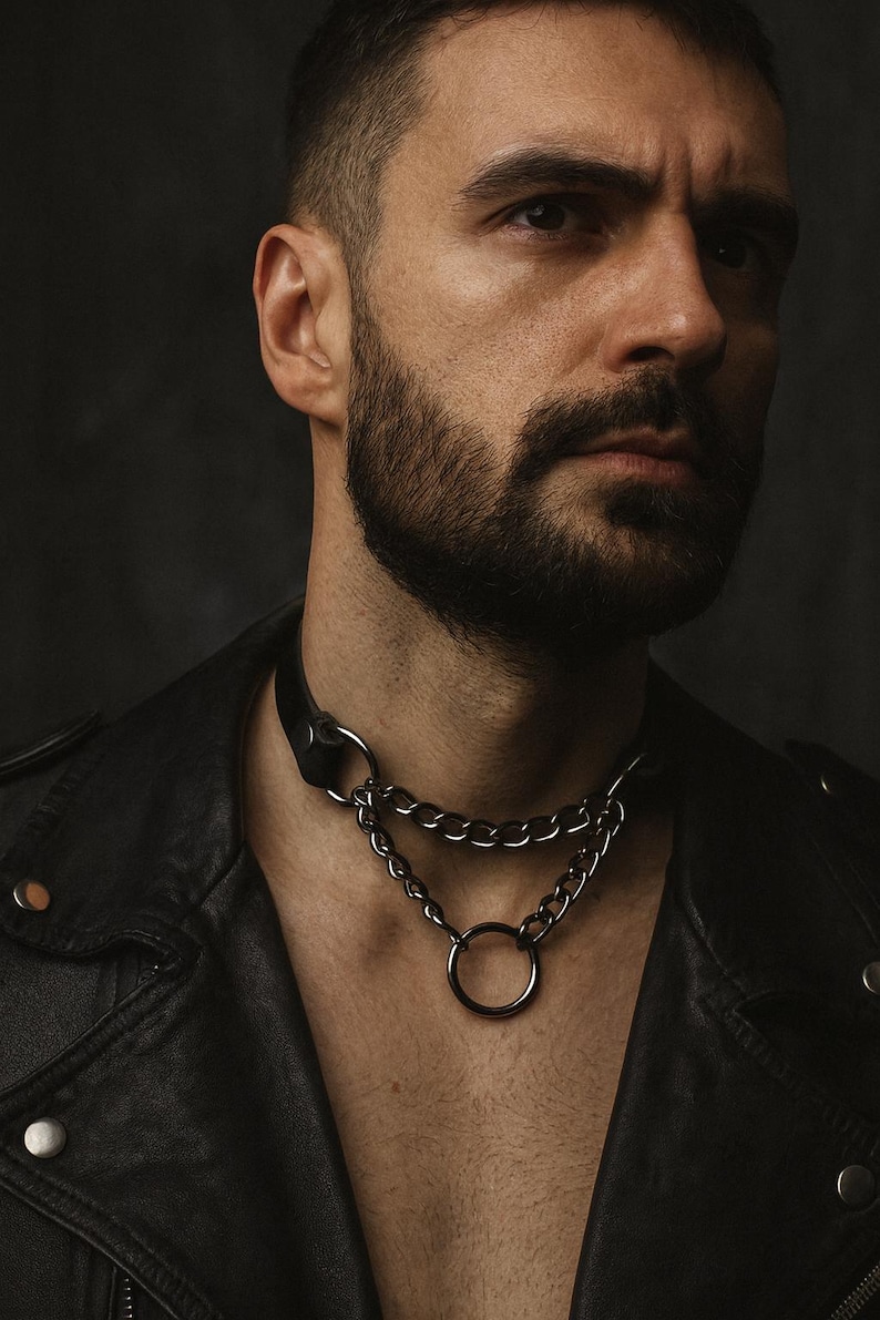 Man wearing black leather chain choker with O-ring – gothic punk fashion jewelry, edgy style necklace.