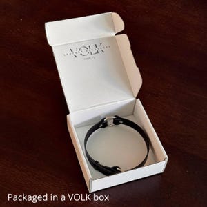 A white box with VOLK logo. Elegant packaging that highlights the premium quality of the accessory.