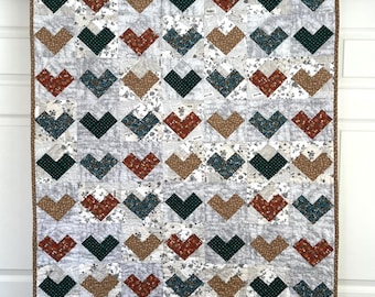 Trapunta per neonato con motivo a cuori, patchwork fatto a mano, colori neutri.