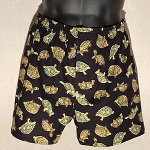 Pode incluir: Boxer preto com um padrão de tartarugas verdes e marrons.
