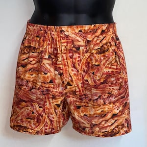 May include: A pair of brown and orange shorts with a pattern of bacon.