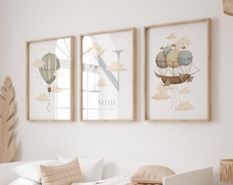 May include: Three framed prints with a light blue and brown color scheme. The prints feature a hot air balloon, a letter N, and a hot air ship. The middle print has the name Noah and the date September 2022.