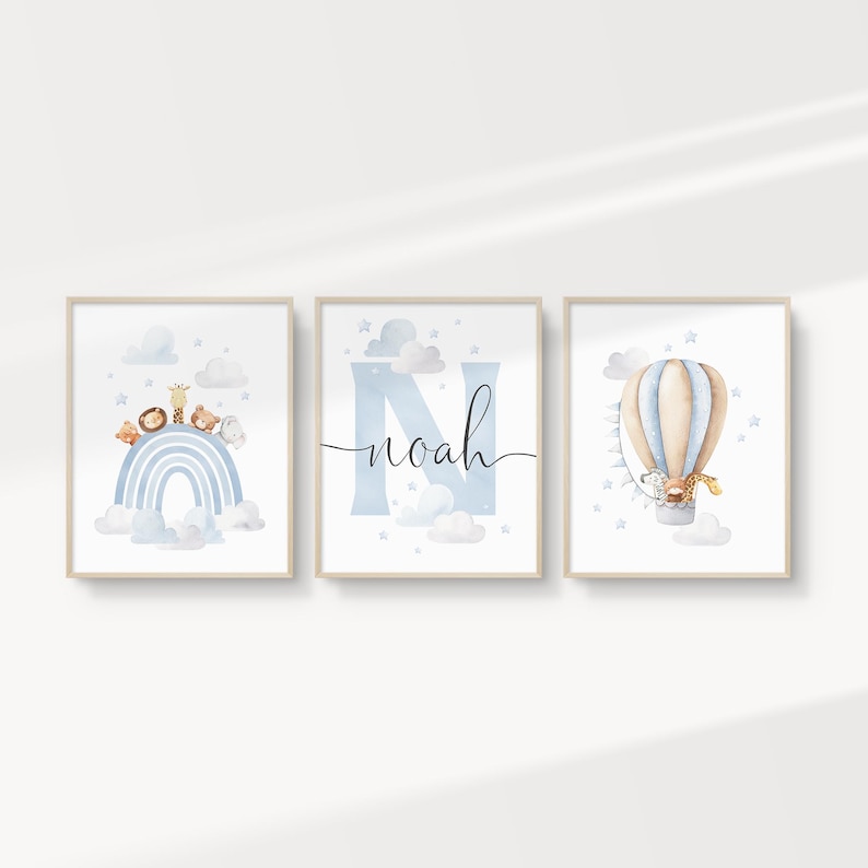 May include: Three framed watercolor prints with a nursery theme. One print features a blue rainbow with animal figures. Another has the name "Noah" in script. The third shows a hot air balloon with a giraffe.