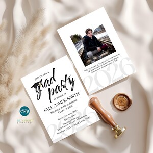 May include: Two rectangular graduation party invitation cards with white backgrounds and black text. One card features a photo of a person on train tracks, the text 2026, and event details. The other card displays the text grad party, Kyle James Smith, and event information. A gold wax seal and a wooden handle stamp are present.