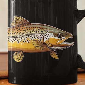 May include: Black coffee mug with a brown trout illustration. The trout is facing right and has brown and yellow scales.