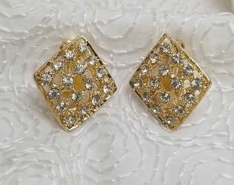 May include: A pair of gold-tone clip-on earrings with a square shape and a clear rhinestone design.