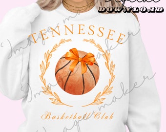 May include: White sweatshirt with an orange basketball with an orange bow on top. The basketball is surrounded by a gold wreath. The text "Tennessee Basketball Club" is printed below the basketball.