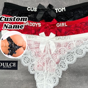 May include: Three pairs of black, red, and white lace underwear with a bow and rhinestones. The underwear has the words "TOM", "CUS", "DADDY'S", "GIRL", "YES", and "DADDY" written on them.