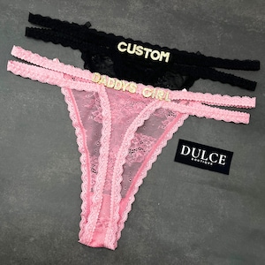 May include: Pink and black lace lingerie with the text "Daddy's Girl" and "Custom" on the black lace. The tag reads "Dulce Boutique".