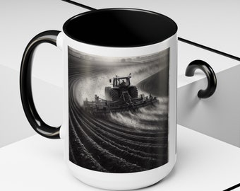 Könnte beinhalten: Eine weiße Keramiktasse mit schwarzem Henkel und Rand. Die Tasse zeigt ein Schwarzweißbild eines Traktors, der ein Feld pflügt.