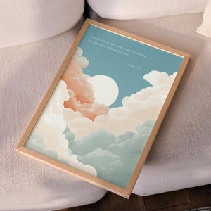 May include: A framed art print depicting a tranquil sky with clouds in peach, white, and blue. A large white sun is visible. The print includes text from John 13:7. The frame is made of light-coloured wood.