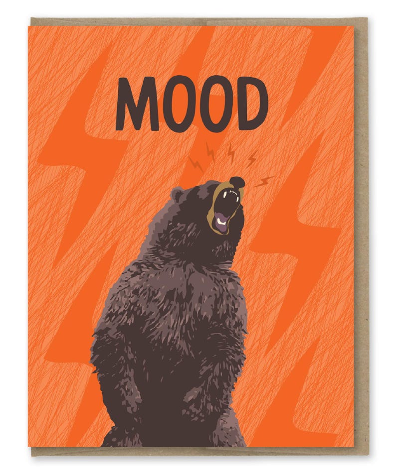 May include: A greeting card with an orange background and a black bear with its mouth open roaring. The text "MOOD" is printed in black at the top of the card.