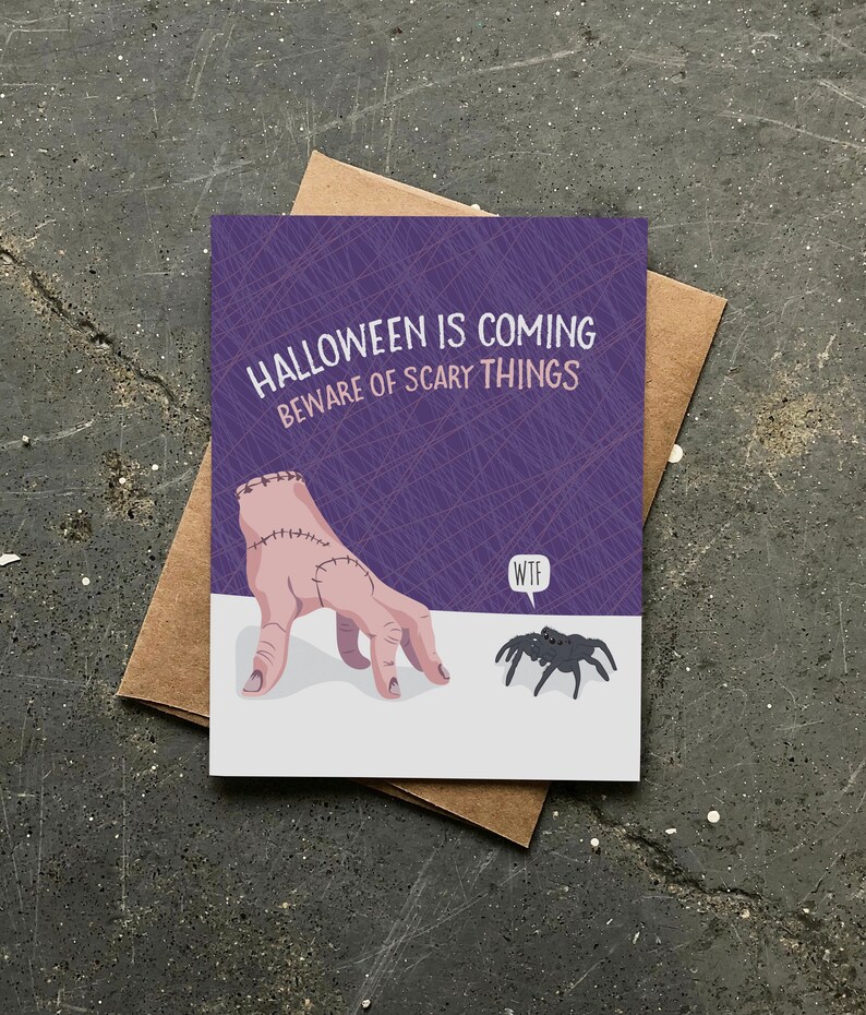May include: A purple card with a stitched hand reaching out to a spider. The card says "Halloween is coming Beware of scary things" and the spider says "WTF".