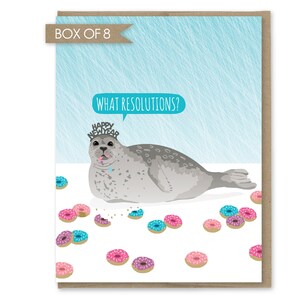 May include: A humorous New Year's card featuring a cartoon seal wearing a "Happy New Year" hat and surrounded by doughnuts. The card reads "What Resolutions?"
