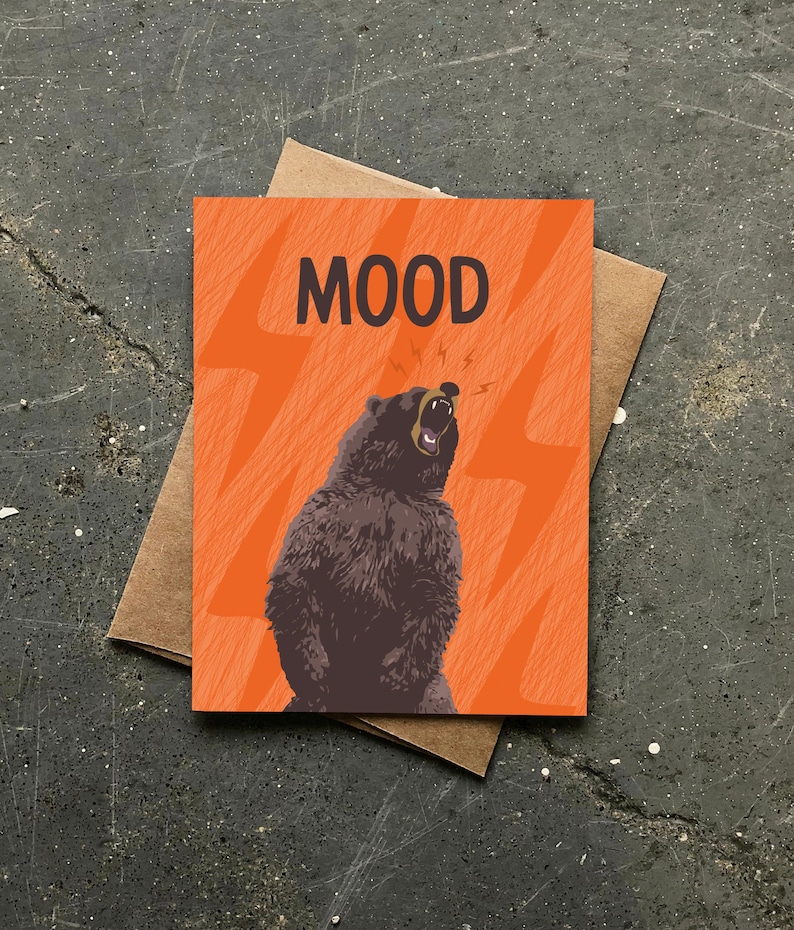 May include: Orange card with a brown bear roaring with lightning bolts around it. The card says "MOOD" in black letters.