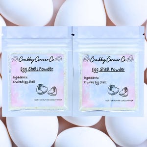 May include: Two white resealable pouches with a white label that says "Crabby Corner Co. Egg Shell Powder" and "Ingredients: Crushed Egg Shell" with a drawing of a broken eggshell. The label also says "Not for Human Consumption".
