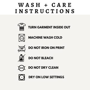 May include: A black and white graphic illustration of laundry care instructions. The instructions include turning the garment inside out, machine washing cold, not ironing on the print, not bleaching, not dry cleaning, and drying on low settings.