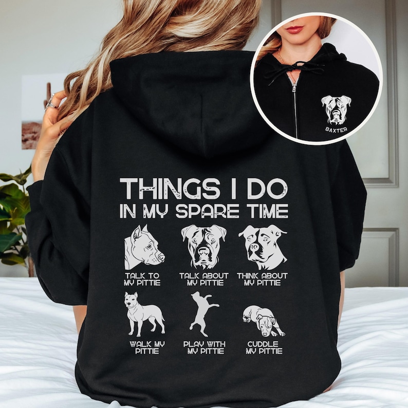 May include: Black hooded sweatshirt with a white graphic that says "Things I do in my spare time" and features a series of illustrations of pit bull terriers with text describing activities like "walk my pittie" and "cuddle my pittie".