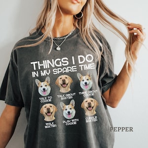 May include: Dark gray t-shirt with the text "THINGS I DO IN MY SPARE TIME" and images of dogs. The shirt features phrases like "Talk to Cookie," "Talk about Baxter," and "Cuddle Baxter."