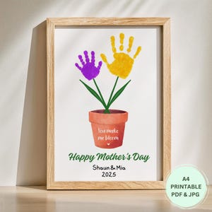 Pode incluir: Um cartão do Dia das Mães imprimível com um vaso de flores com impressões de mãos e o texto "You make me bloom" e "Happy Mother's Day". O cartão é assinado "Shaun & Mia 2025".