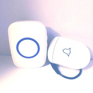 May include: A white wireless doorbell system with a blue ring detail on the main unit and a bell icon on the smaller unit. The system includes a black cable connecting the two components.