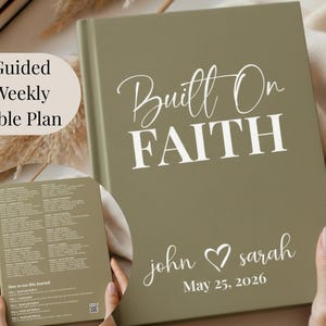 May include: An olive green journal with the words "Built On FAITH" in white script. Below, it reads "john ♡ sarah May 25, 2026." A smaller booklet with text is held next to the journal. The text "Guided Weekly Bible Plan" is in the upper left corner.
