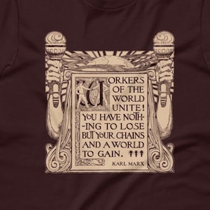Puede incluir: Una camiseta marr&oacute;n con un gr&aacute;fico de estilo vintage que presenta una cita de Karl Marx: "&iexcl;Trabajadores del mundo, un&iacute;os! No ten&eacute;is nada que perder m&aacute;s que vuestras cadenas y un mundo que ganar."