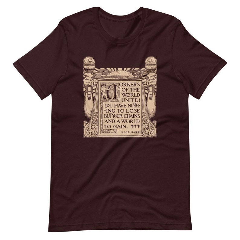 Puede incluir: Una camiseta marr&oacute;n con un gr&aacute;fico de estilo vintage que presenta una cita de Karl Marx: "&iexcl;Trabajadores del mundo, un&iacute;os! No ten&eacute;is nada que perder m&aacute;s que vuestras cadenas y un mundo que ganar."