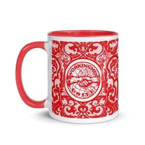 May include: White ceramic mug with a red interior and a red design. The design features a red circle with the text "Workingmen Unite" and a handshake inside the circle. The circle is surrounded by a red ornate design.