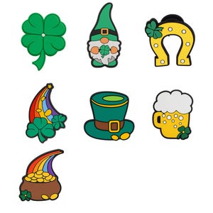 Op de afbeelding: Een verzameling St. Patrick's Day-bedels. Inclusief een groene klaver, een kabouter, een gele hoefijzer met een groene klaver, een regenboog met klavers, een groene hoed, een bierpul en een pot met goud.