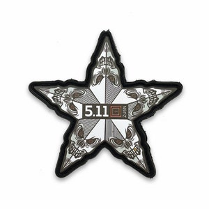 以下が含まれることがあります： 5.11のタクティカルパッチで、黒と白の五芒星デザイン。星は5つの頭蓋骨で構成され、中央に5.11のロゴがあります。