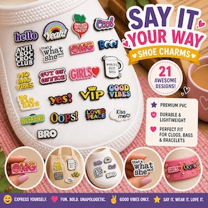 May include: A collection of 21 shoe charms in various colors and designs, including phrases like "Hello," "OMG," and "Good Vibes." The charms are shown attached to a white shoe and other accessories. The text "Say It Your Way" is also visible.
