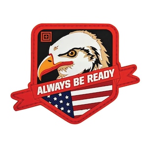 Może przedstawiać: Naszywka z głową bielika z żółtym dziobem i okiem na czarnym tle i czerwonej obwódce. Tekst „ALWAYS BE READY” znajduje się nad wzorem amerykańskiej flagi.
