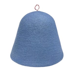 May include: A light blue felt sauna hat with a rounded top and a flared base. The hat has a small red and white loop at the top for hanging. The hat is made of a soft, textured material.