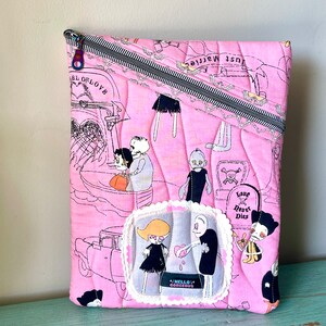 May include: Pink quilted zippered pouch with a black and white illustration of skeletons and the text "Just Married" and "Love Never Dies".