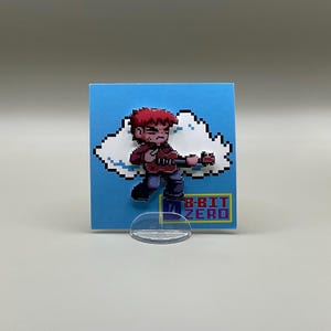 May include: A red-haired pixelated character playing a guitar, standing on a white cloud. The character is wearing a red shirt and blue jeans. The background is a light blue square with the text "8-BIT ZERO" in a colorful font.
