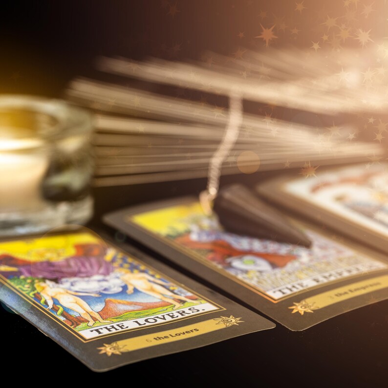 May include: Two tarot cards, The Lovers and The Emperor, are laid out on a black surface. A pendulum hangs above the cards, with a candle in the background.