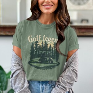 ビッグフット ゴルフ レジェンド T シャツ、面白いゴルフ ギフト、神話の生き物愛好家向け T シャツ、ユニークなゴルフ シャツ、ビッグフット ドライビング ゴルフ カート T シャツ