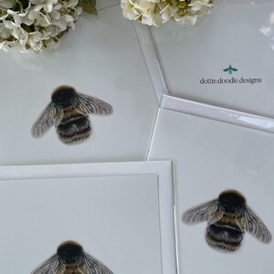 K&ouml;nnte beinhalten: Drei wei&szlig;e Karten mit jeweils einer Illustration einer schwarzen und gelben Hummel. Die Karten sind leer und haben einen wei&szlig;en Rand. Auf einer Karte steht der Text "dottie doodle designs" gedruckt.