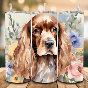May include: A watercolor illustration of a brown and white Cocker Spaniel dog with floral accents. The dog is looking directly at the viewer with a soft expression. The flowers are in shades of pink, yellow, blue, and green.