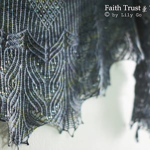 May include: A close-up of a gray knitted shawl with a delicate lace pattern and iridescent beads. The shawl is draped over a white surface. The text "Faith Trust & Pixie Dust" is visible in the upper right corner of the image.