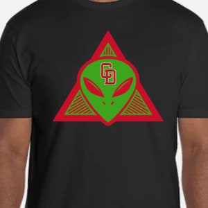 May include: Black t-shirt with a red triangle design featuring a green alien head with the letters "GD" inside.