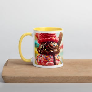 May include: A white ceramic mug with a yellow rim features a colourful image of a triple scoop ice cream cone with chocolate, pink, and strawberry ice cream topped with sprinkles.