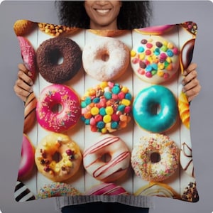 May include: A pillow with a colorful pattern of donuts. The donuts are glazed, sprinkled, and have different toppings.