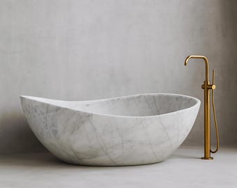 May include: A white marble bathtub with gray veining, featuring a unique, curved design. A gold-colored faucet stands beside the tub, adding a touch of luxury to the bathroom setting.