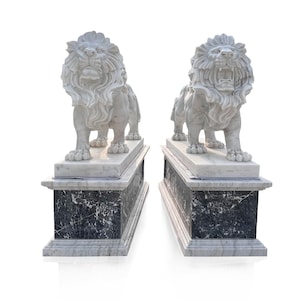 Pareja de estatuas de leones blancos con pedestales