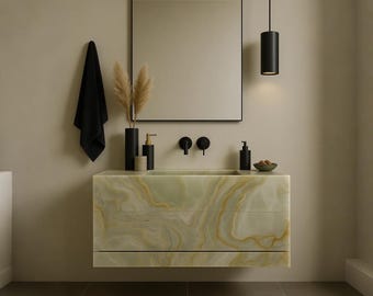 May include: A modern bathroom vanity with a light green and gold marble-like finish. The vanity has a rectangular shape with three drawers and is mounted on the wall. A black framed mirror hangs above the vanity, with black fixtures and a black towel. A black pendant light hangs from the ceiling.